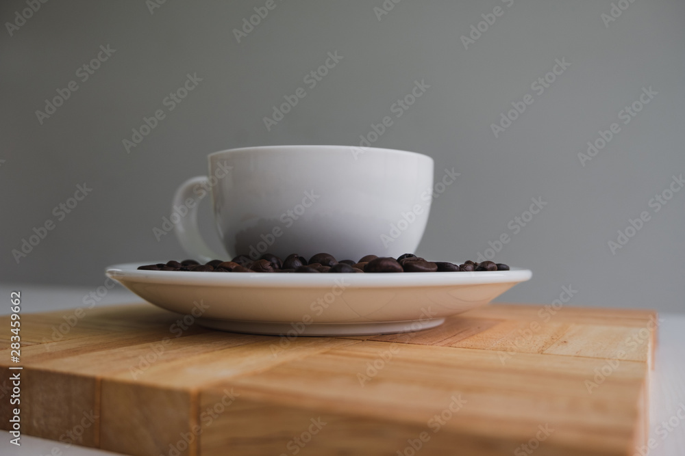 white cup and coffee bean on wood block