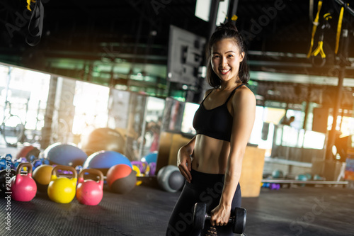 Sporty beautiful woman exercising with dumbbell weight training equipment with blurry background, Healthy life and gym exercise equipments and sports concept, with copy space