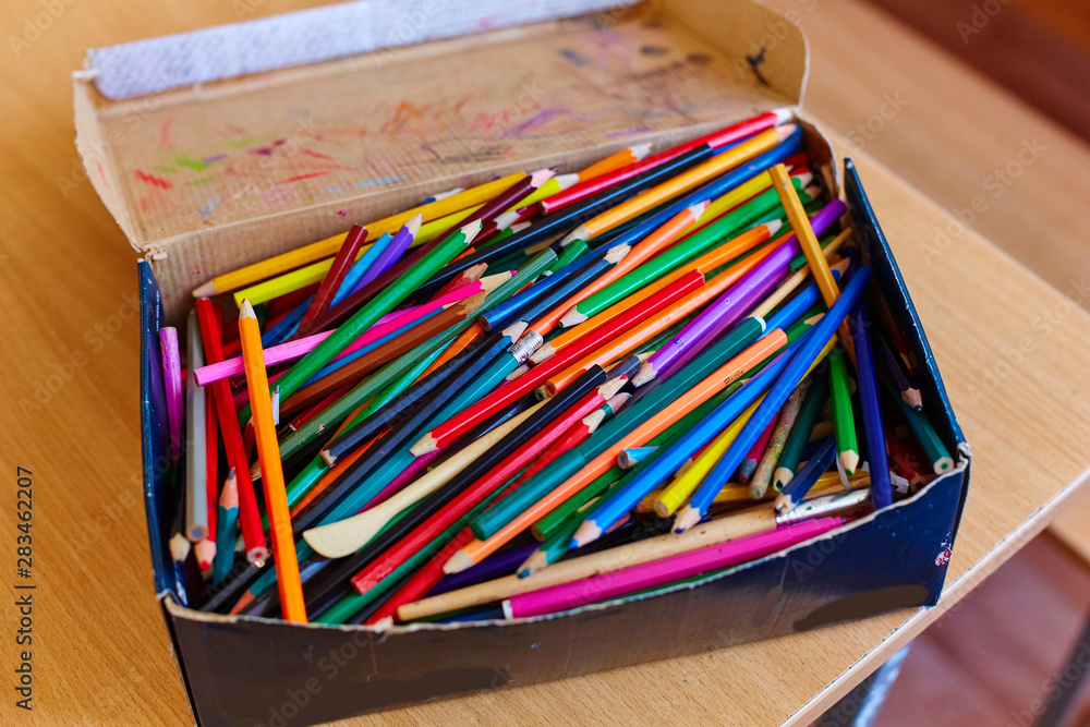 A lot of Old and broken colorful Pencils in cardboard box A lot of Old and broken colorful Pencils in cardboard box