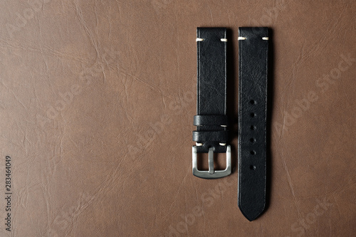 Black leather watch strap with stainless buckle on leather background, Craft and handmade watch bracelet, Luxury classic and vintage style.
