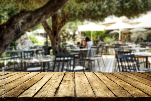 Table background and restaurant outside on sunny day in distance. Empty space for products and decoration. © magdal3na