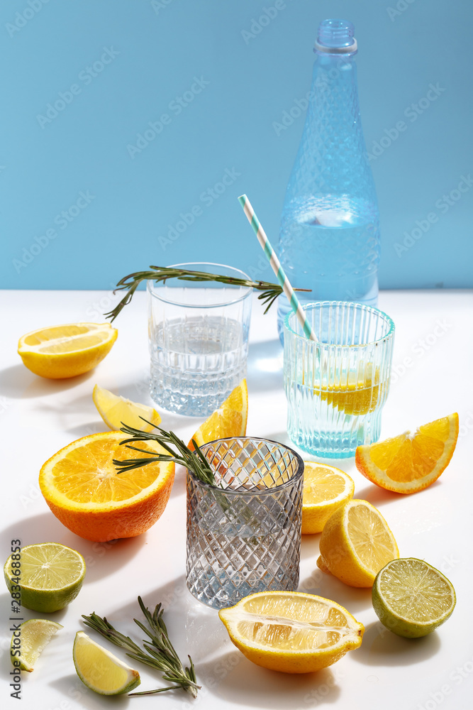 Composition of glassware and cut citrus fruits on a white background. The concept of making homemade lemonade.