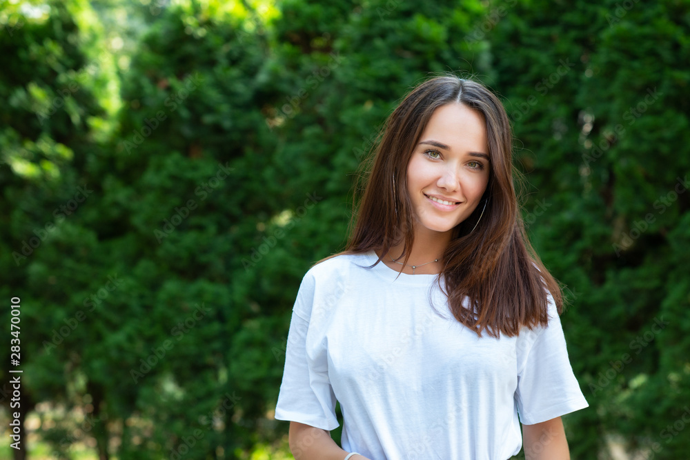 Portrait of beautiful young girl posing in summer park. Majestic woman's beauty. Youth, happiness, lifestyle.