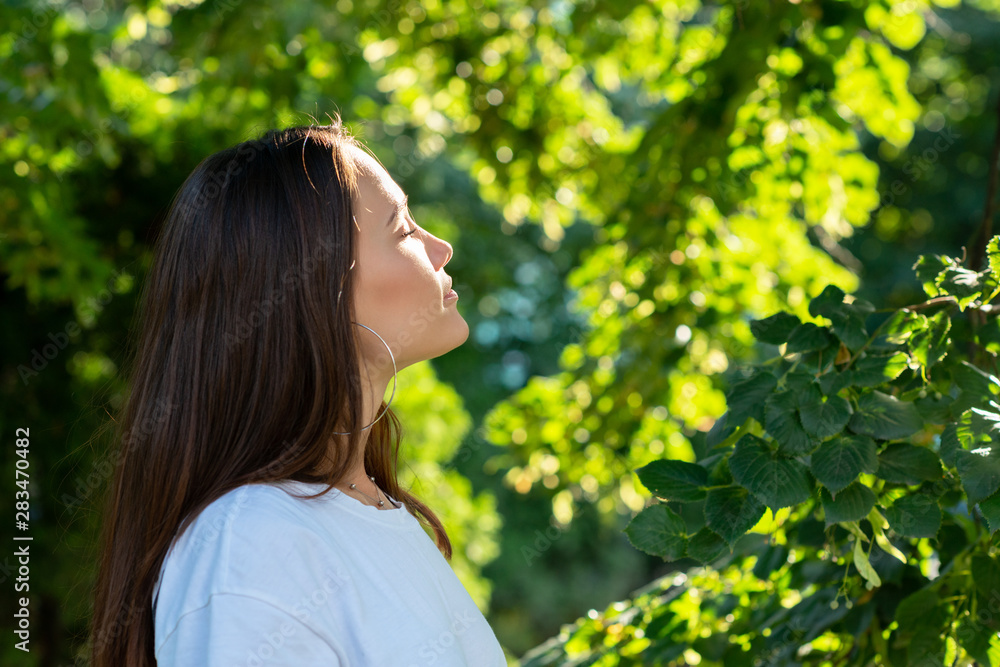 Portrait of beautiful young girl posing in summer park. Majestic woman's beauty. Youth, happiness, lifestyle. Portrait of beautiful young girl posing in summer park. Majestic woman's beauty. Youth, happiness, lifestyle.