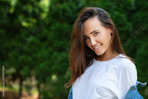 Portrait of beautiful young girl posing in summer park. Majestic woman's beauty. Youth, happiness, lifestyle.
