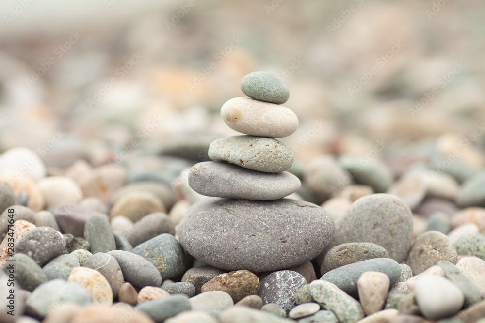 Stones tower with blurred sea background. Pyramid on the center. Zen garden. Spa set. Stones tower with blurred sea background. Pyramid on the center. Zen garden. Spa set.
