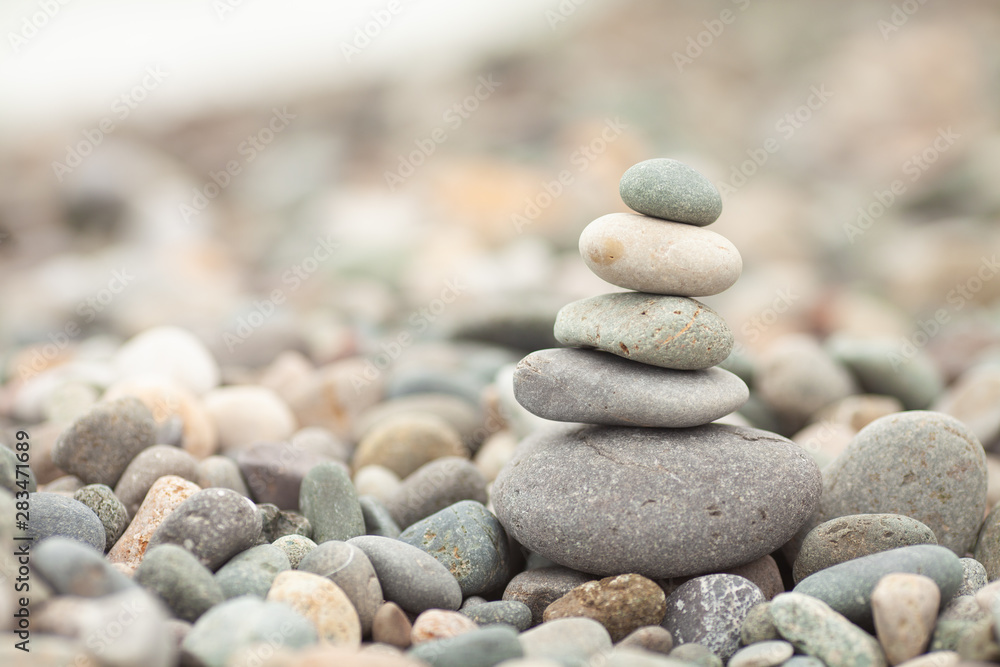 Stones tower with blurred sea background. Pyramid on the center. Zen garden. Spa set. Stones tower with blurred sea background. Pyramid on the center. Zen garden. Spa set.