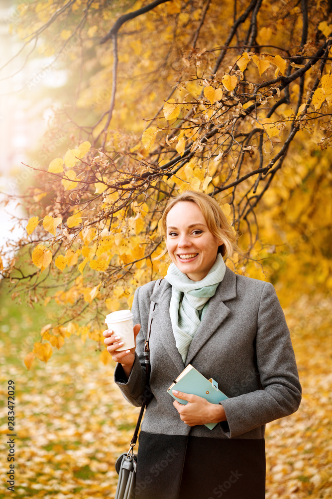 Young smiling woman walking and drinking take away coffee Young smiling woman walking and drinking take away coffee