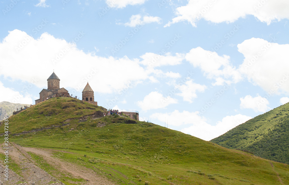 Stepantsminda, Gergeti, Georgia. Famous Landmark Gergeti Trinity Tsminda Sameba Church In Summer. Gergeti Trinity Tsminda Is National Heritage Of Georgia.