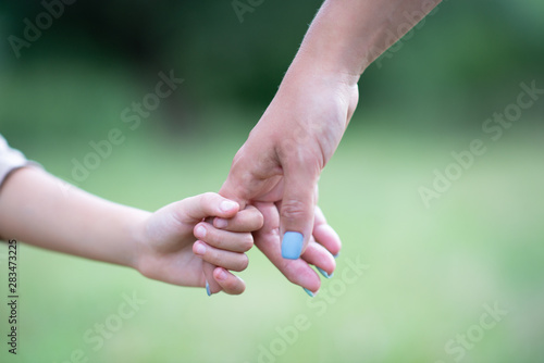 Woman's and kid's hands. Mother leads her child, summer nature outdoor. Parenting, togetherness, help, union, childhood, trust, family concept. © Khorzhevska