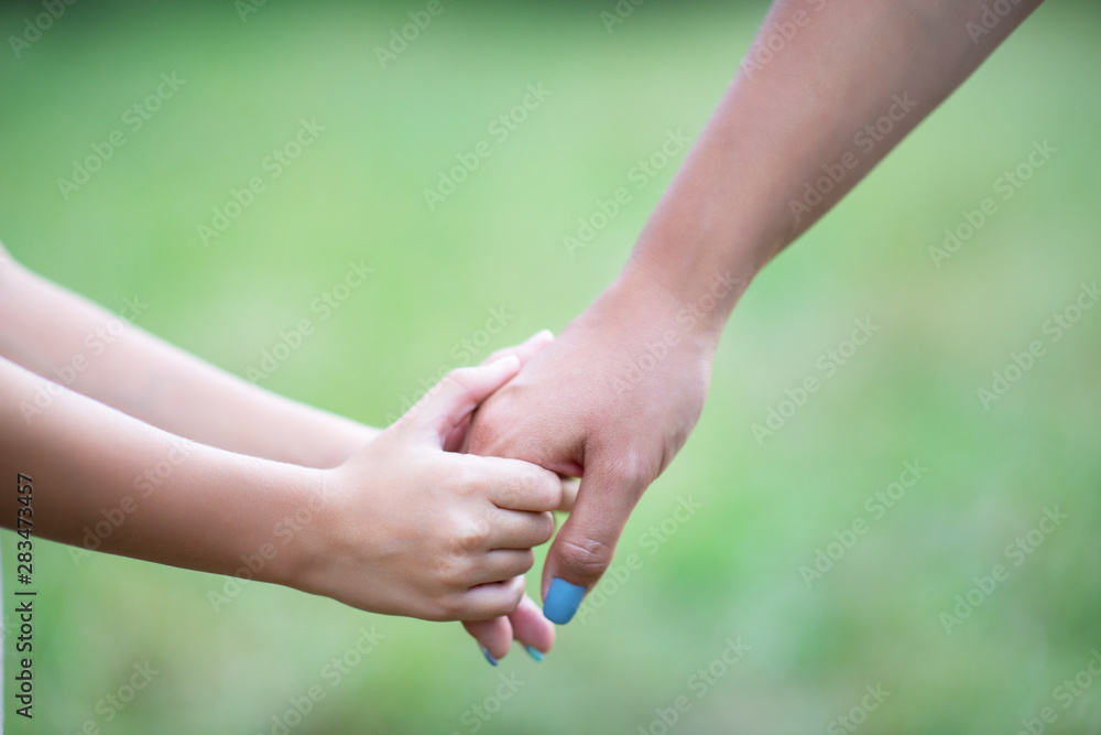 Woman's and kid's hands. Mother leads her child, summer nature outdoor. Parenting, togetherness, help, union, childhood, trust, family concept. Woman's and kid's hands. Mother leads her child, summer nature outdoor. Parenting, togetherness, help, union, childhood, trust, family concept.