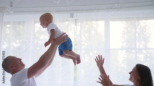 family of four stands in a white room against