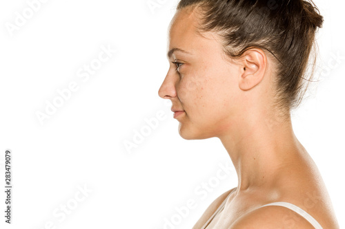 Profile of young smiling woman without makeup on white background