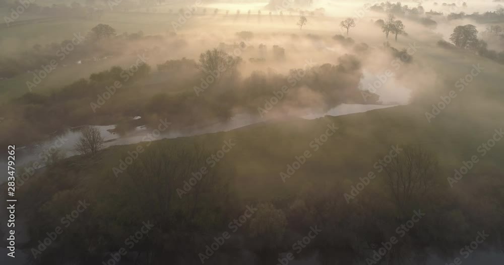 Aerial shot of foggy sunrise over a river in the English countryside. Aerial shot of foggy sunrise over a river in the English countryside.