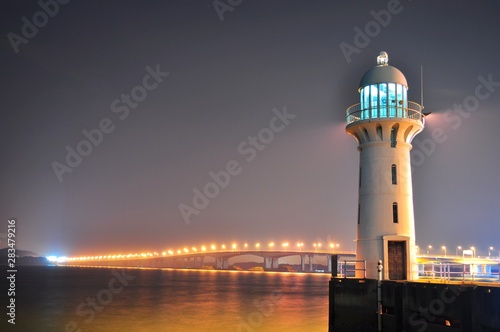 A lighthouse in Tuas (in the west of Singapore) with Second Link bridge (connecting Singapore and Malaysia) as background by night..
