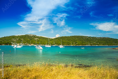 Scenic view of Kosirina beach bay on Murter island in Croatia, sailing boats and yachts on blue sea