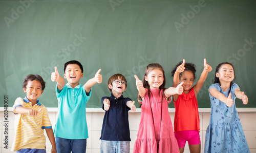 Multi-ethnic group of school children standing in classroom