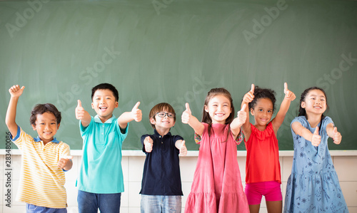 Multi-ethnic group of school children standing in classroom