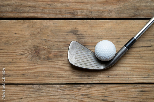 golf ball and golf club on the wooden table background