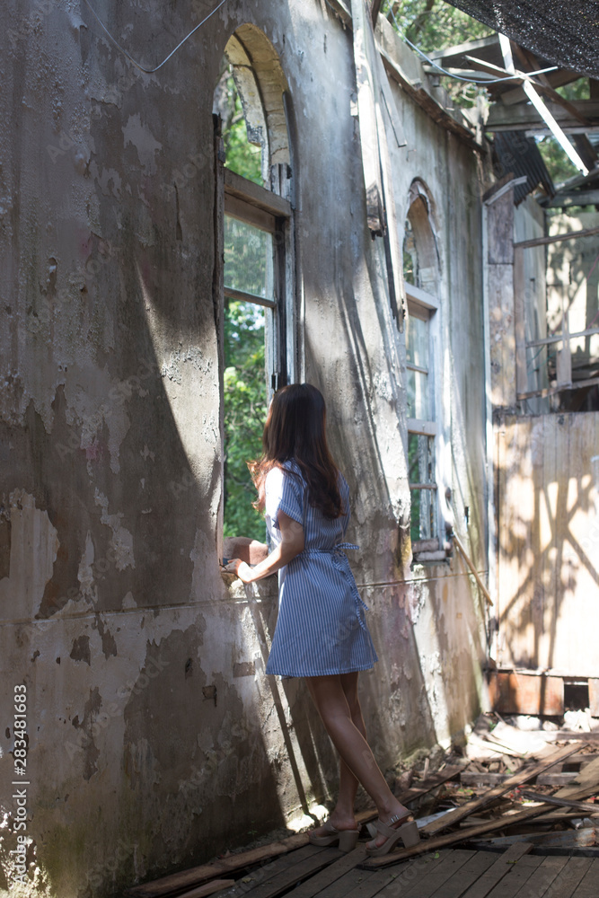 Woman inside the old abandoned church. sunny day window