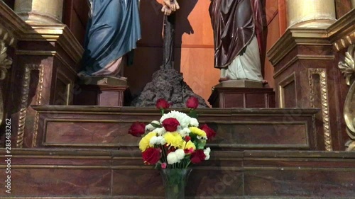 A bouquet of flowers and Jesus on the altar next to the Virgin Mary, a work of art. photo