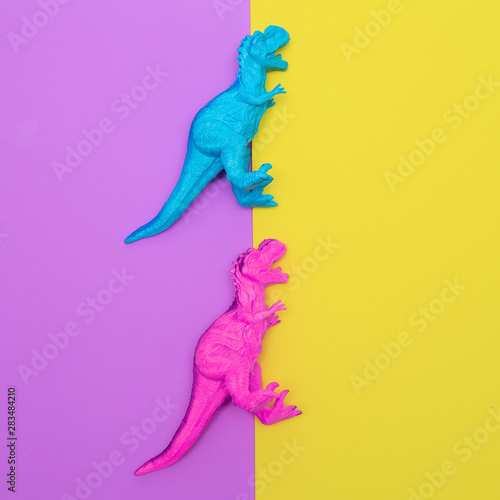 Toys dinosaurs on a colored background. Flat lay minimal art