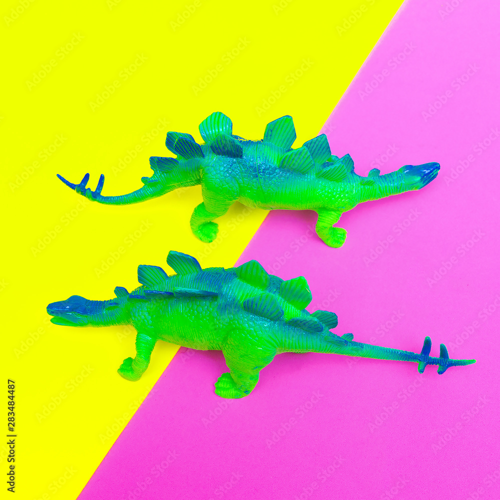 Fototapeta premium Plastic two green dinosaurs on colored background. Minimal flat lay art.