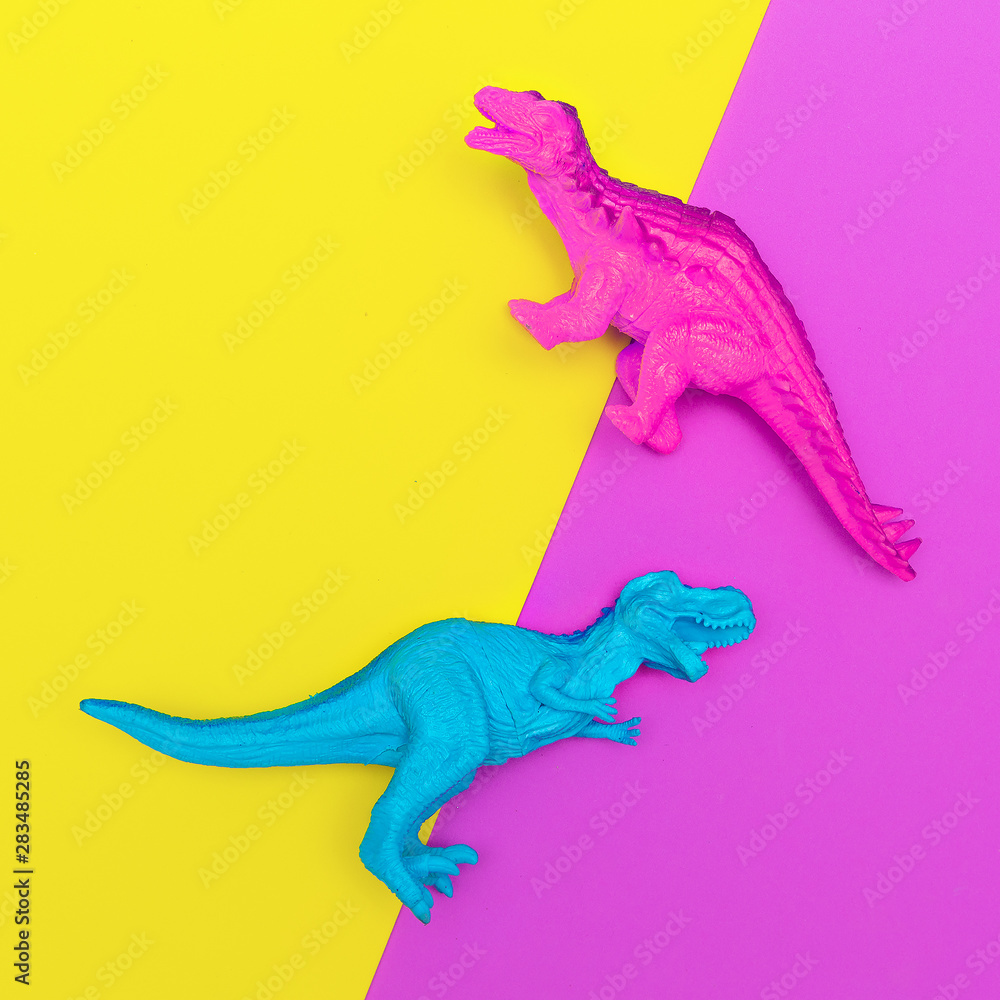 Fototapeta premium Plastic dinosaurs on a colored background. Minimal flat lay art