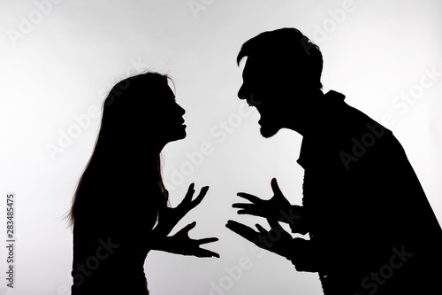 Relationship difficulties, conflict and abuse concept - man and woman face to face screaming shouting each other dispute silhouette isolated on white background photo