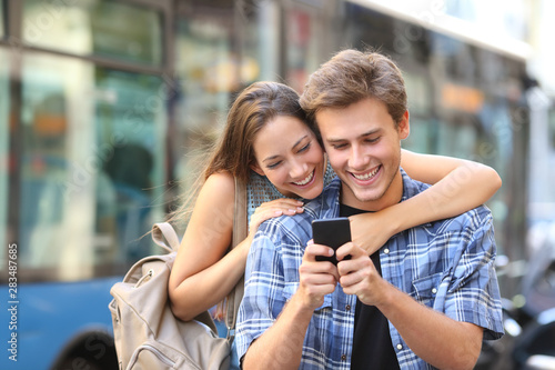 Couple using phone with a bus in the background