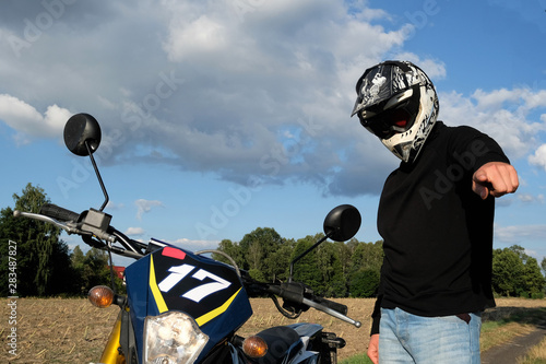 man with a motocycle in a helmet pointing finger