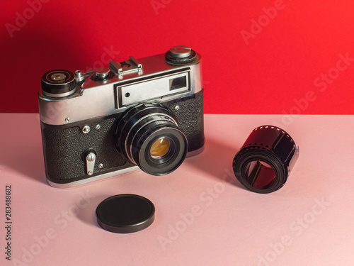 Old film camera on a Living Coral Trend vintage, travel top view copy space