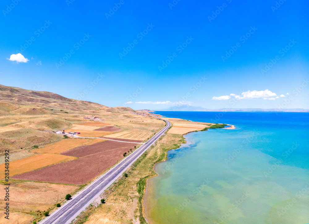 Aerial view of Lake Van the largest lake in Turkey, lies in the far east of that country in the provinces of Van and Bitlis. Fields and cliffs overlooking the crystal waters. Roads along the lake