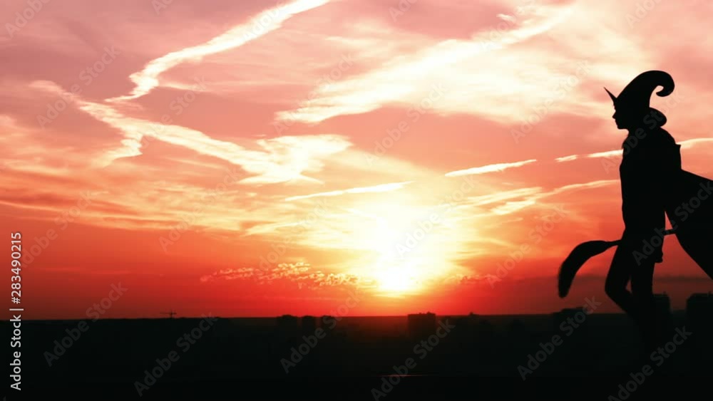 witch in hat and fluttering cloak with besom walks sunrise view on the city slow motion halloween witch in hat and fluttering cloak with besom walks sunrise view on the city slow motion halloween