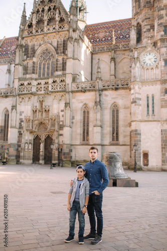 Two brothers walk in the city together. Happy family outside