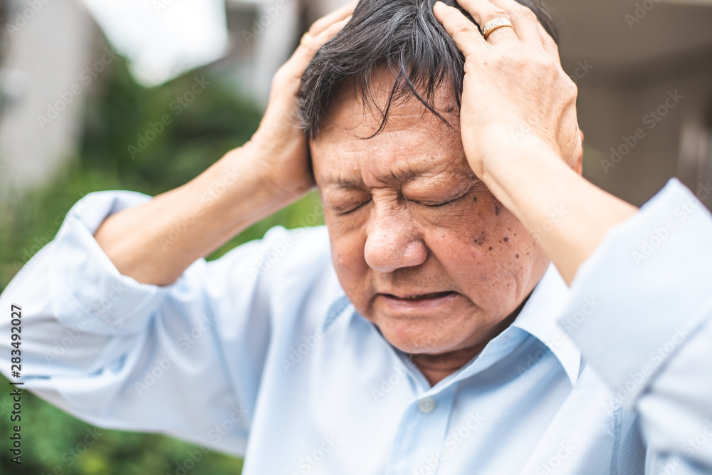 Portrait of an elderly man with headache.senior man covering his face with his hands.vintage tone.. Portrait of an elderly man with headache.senior man covering his face with his hands.vintage tone..