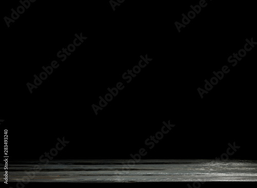 Wooden table background with black wall. Empty space for decoration and products.