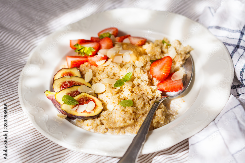 Quinoa breakfast porridge with strawberries and figs in white plate. Healthy breakfast concept. Quinoa breakfast porridge with strawberries and figs in white plate. Healthy breakfast concept.