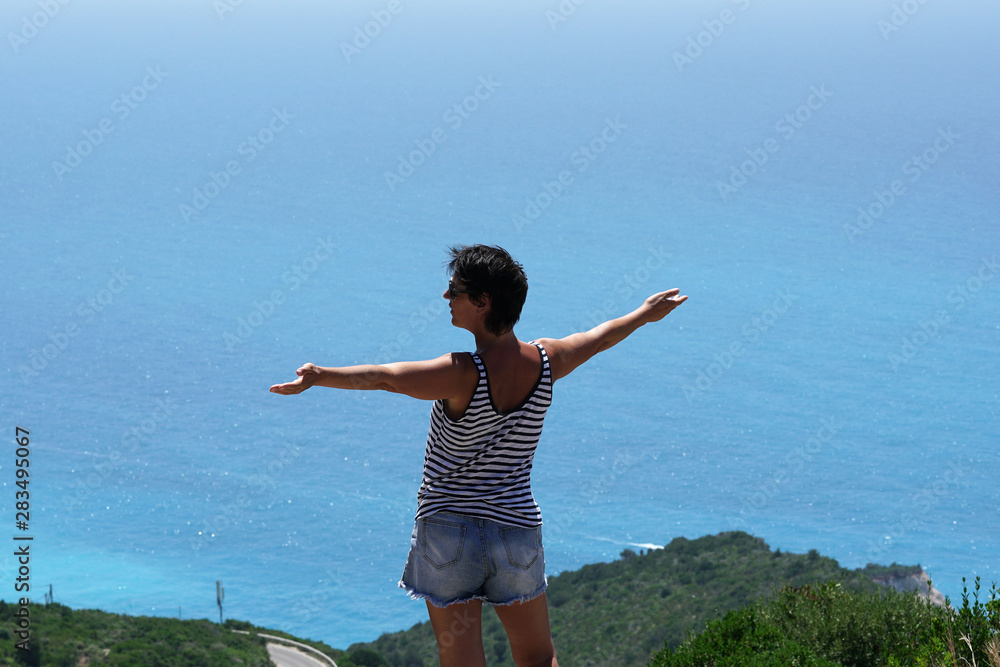 A tourist enjoys the splendid view of the panorama of Porto Katsiki in Lefkada A tourist enjoys the splendid view of the panorama of Porto Katsiki in Lefkada
