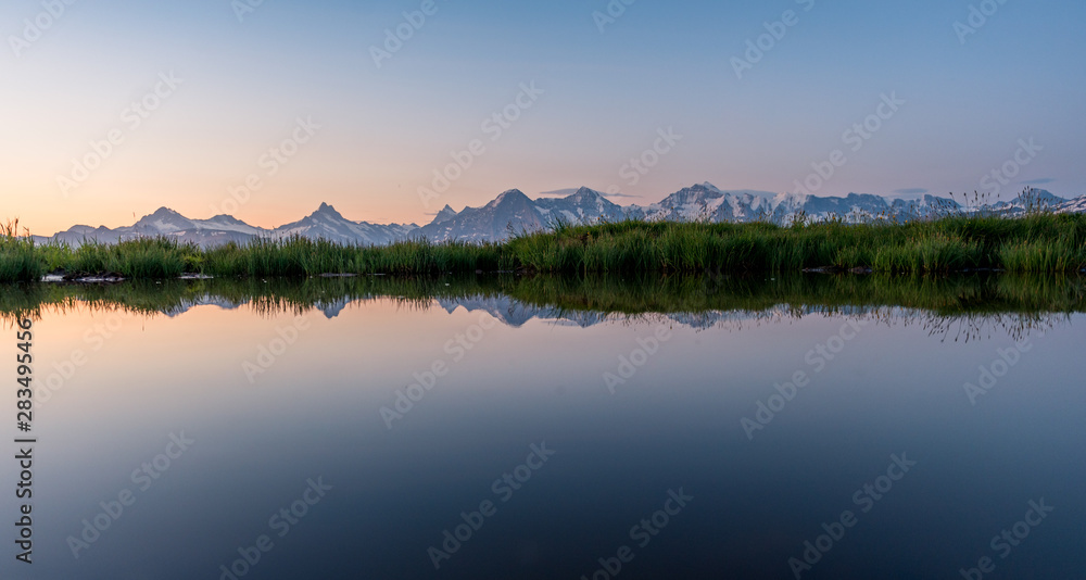 Eiger, Mönch und Jungfrau spiegeln sich in kleinem Tümpel im Morgenrot