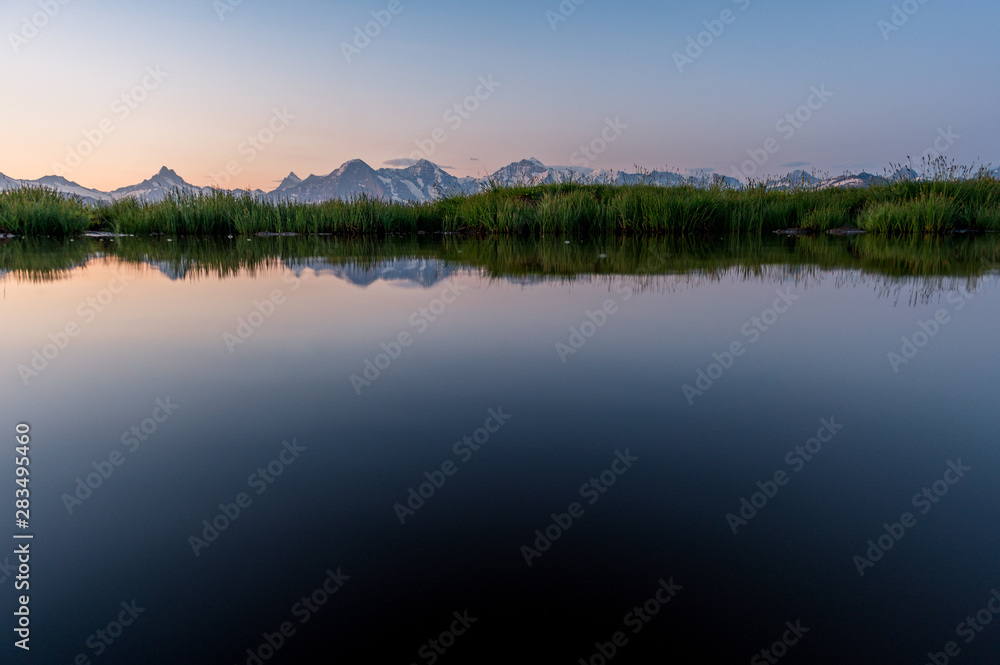 Eiger, Mönch und Jungfrau spiegeln sich in kleinem Tümpel im Morgenrot