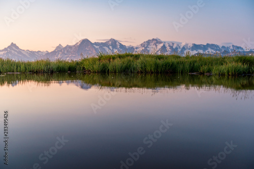 Eiger, Mönch und Jungfrau spiegeln sich in kleinem Tümpel im Morgenrot © schame87
