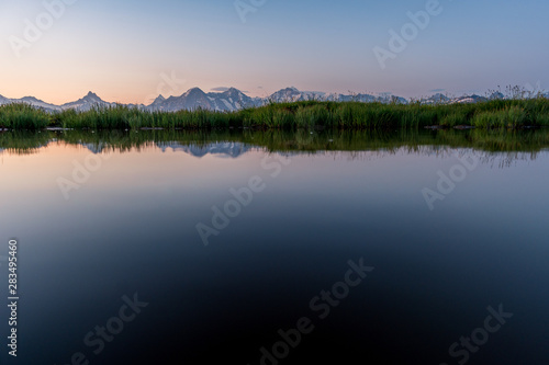 Fototapeta Naklejka Na Ścianę i Meble -  Eiger, Mönch und Jungfrau spiegeln sich in kleinem Tümpel im Morgenrot