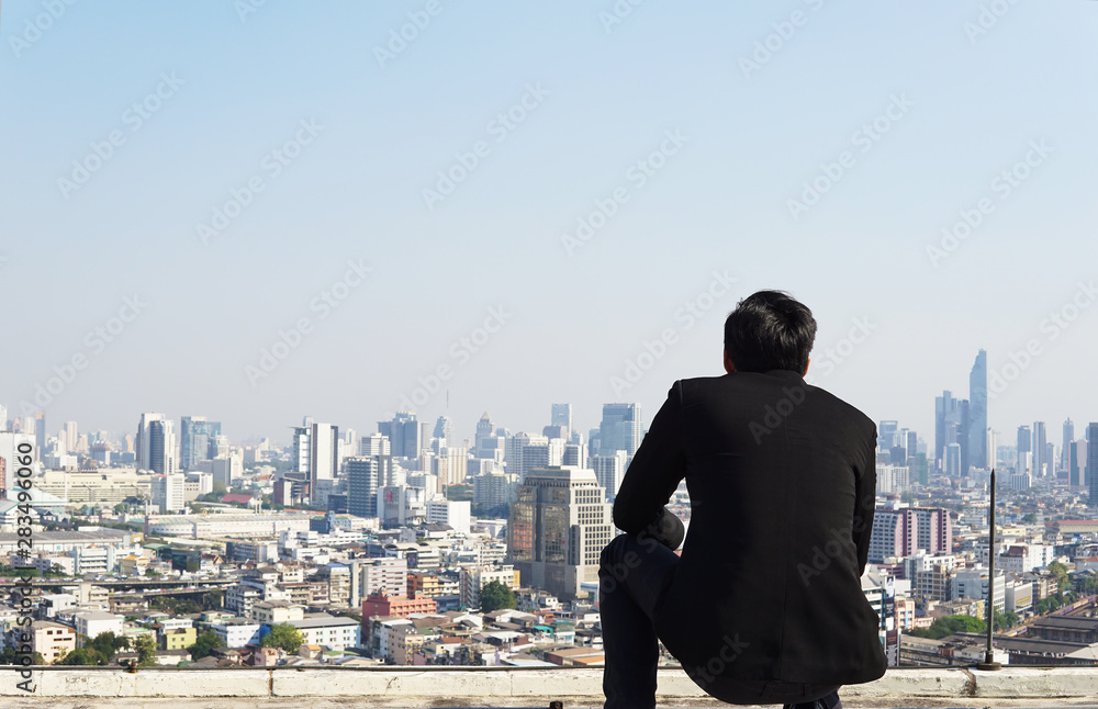 Businessman looking city to the future on rooftop Businessman looking city to the future on rooftop