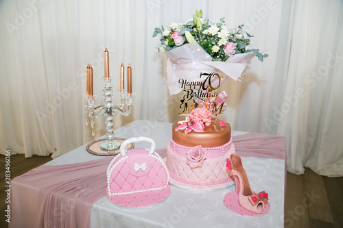happy 70th birthday mom in rose gold on birthday cake with shoe and handbag fresh flowers