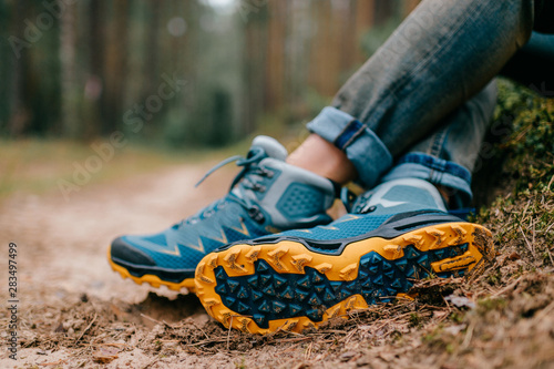 Male legs wearing sportive hiking shoes outdoor. Mens legs in trekking boots for outdoor activity