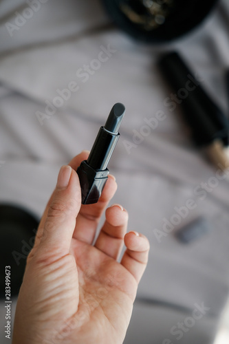 Black lipstick balm in woman hand