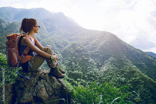 Young woman backpacker enjoy the view at mountain peak photo