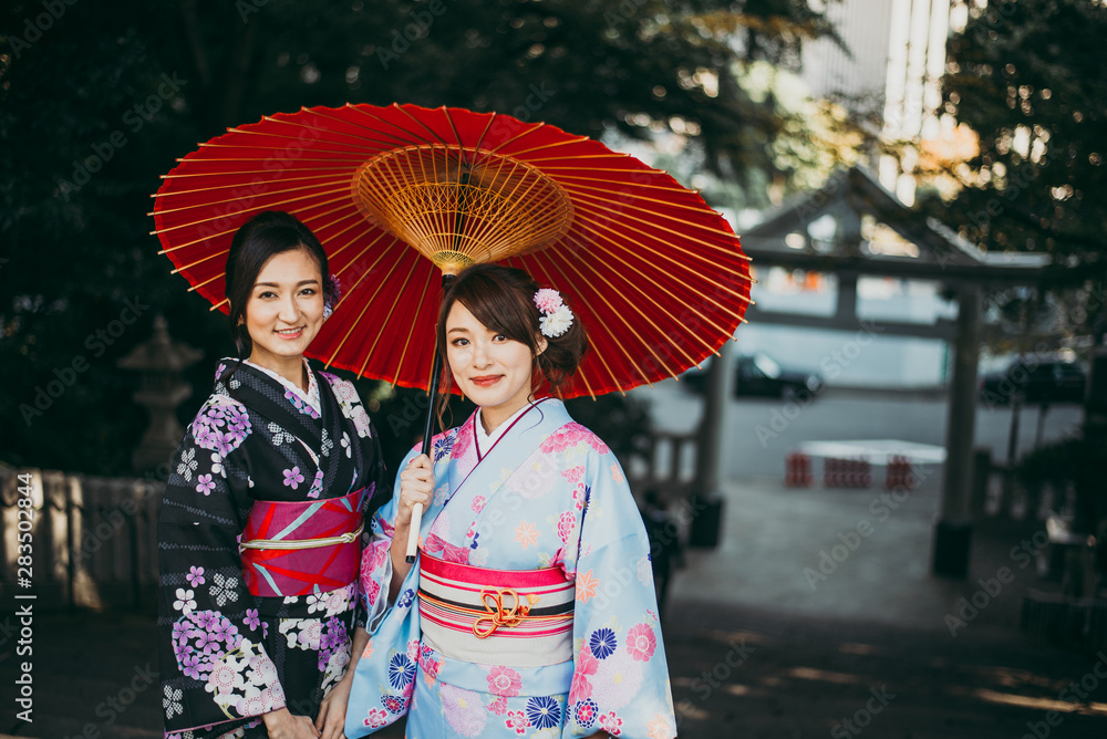 Fototapeta premium Two japanese girls wearing kimonos traditional clothes, lifestyle moments