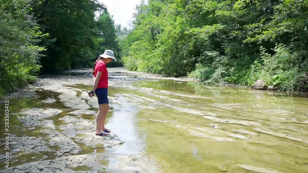 summer pastime.country rest.tourism and travel.young pretty woman walks along the banks of a picturesque mountain river on a summer sunny day summer pastime.country rest.tourism and travel.young pretty woman walks along the banks of a picturesque mountain river on a summer sunny day